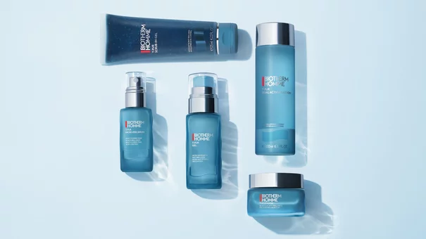 Verschiedene blaue Biotherm Homme Pflegeprodukte auf hellem Hintergrund angeordnet.