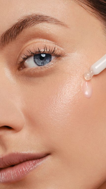 Femme qui applique un serum sur son visage